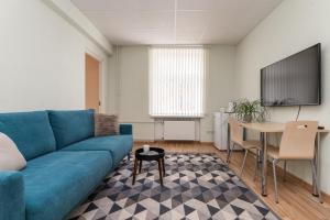 科赫特拉-耶尔韦Virumaa Hostel的客厅配有蓝色的沙发和桌子