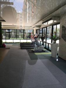 曼谷I Condo Suvarnabhumi Airport的一个带跑步机的健身房,位于一栋带窗户的建筑内