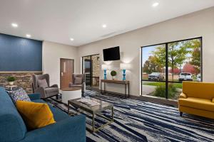 哈德森Comfort Suites Hudson I-94的客厅配有蓝色的沙发和电视
