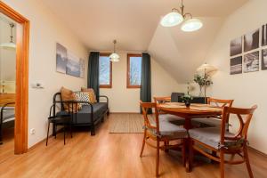 佐洛恰尼Thermal Valley Apartman - Batthyány Villapark的用餐室以及带桌椅的起居室。
