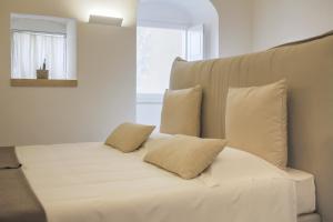 马泰拉Sant'Angelo, Matera的一张带白色床单和枕头的床