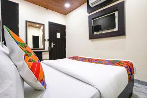孟买FabExpress Gulshan Grand的卧室配有一张床铺,墙上配有电视