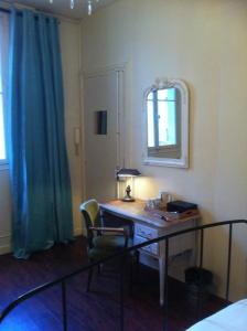 巴黎巴黎一间屋住宿加早餐旅馆的一间卧室配有一张带台灯和镜子的书桌