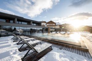 阿维兰奥Hotel Viertler的一座在雪中设有游泳池的建筑