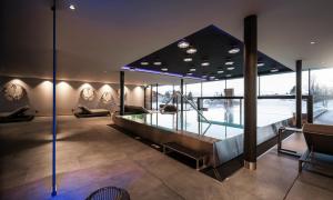 阿维兰奥Hotel Viertler的一间设有玻璃桌和游泳池的房间