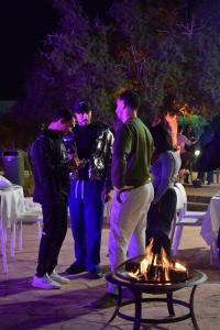 塔哈佐特Lunja Village - Agadir的一群人晚上站在火炉旁