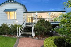 布里斯班The Indooroopilly Queenslander - 4 Bedroom Family Home - Private Pool - Wifi - Netflix的前面有楼梯的房子