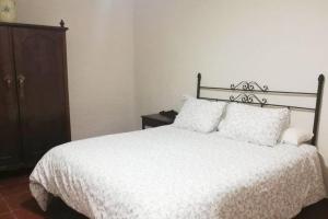 罗德里戈城Casa rural Los Barreros的卧室配有白色床和木柜