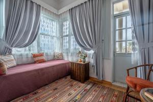 安塔利亚图利潘别墅酒店的一间卧室设有大窗户和粉红色的沙发