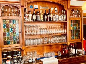 SchalksmühleHotel zur Post的一间酒吧,提供玻璃杯和酒瓶