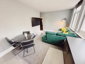 泰恩河畔纽卡斯尔3 Bedroom Apartment in the Heart of Newcastle - Modern - Sleeps 6的客厅配有绿色沙发和桌子