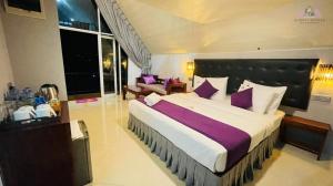 TalawakeleAlmost Heaven的大卧室配有一张带紫色枕头的大床