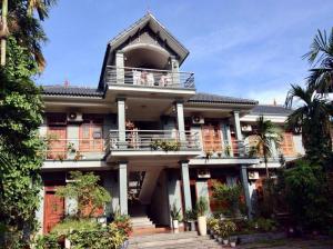 Nhà Nghỉ Phương Chi Mạo Khê的带阳台和棕榈树的大型房屋