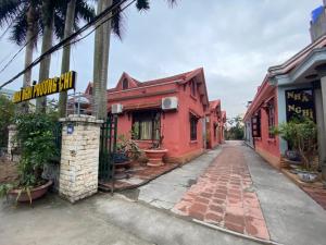 Nhà Nghỉ Phương Chi Mạo Khê的一条空的街道,有红色的建筑和街道标志