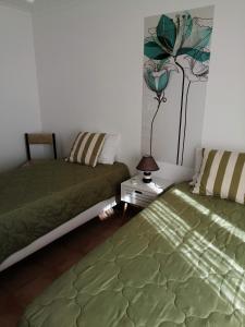 卡巴纳斯·德·塔维拉Apartamento Vista Mar的一间卧室配有两张床和床头灯。