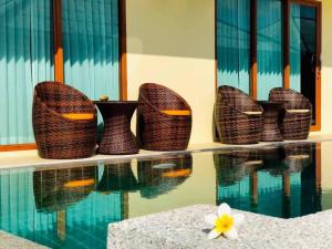 拉迈乌托邦度假村酒店的一组柳条篮子坐在游泳池旁