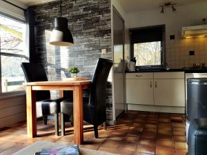 奥特罗Tiny House de Berken的厨房配有木桌和黑色椅子