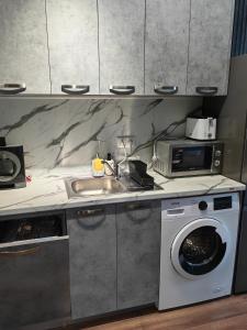 普罗夫迪夫Luxury Apartment/Studio的厨房配有洗衣机和水槽