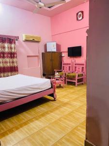 木尔坦Hotel New Star的粉红色的房间,配有床和电视