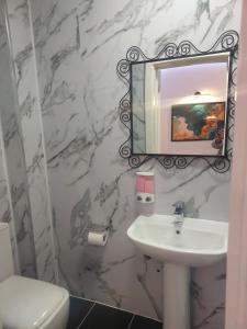 艾弗Pinewood Guest House的浴室设有白色水槽和镜子