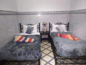 马拉喀什HOTEL EL AMAL的卧室内两张并排的床