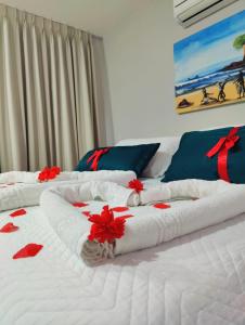 皮帕Pousada Waikiki Boutique的两张大白色床,并配以红色鲜花