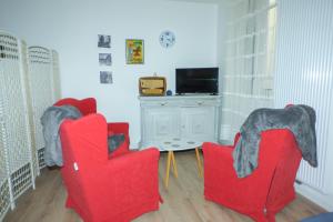 普拉德莫洛拉普雷斯特Serra-Vernet del Roser的客厅配有2把红色椅子和电视