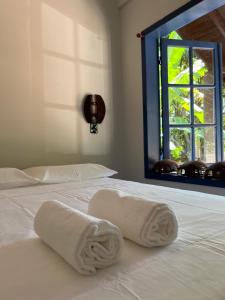 贝卢港Pousada Maikai Garden的白色床上的两条毛巾,带窗户