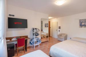 罗卡拉索Hotel Rasinus的酒店客房配有一张床、一张书桌和一台电视。