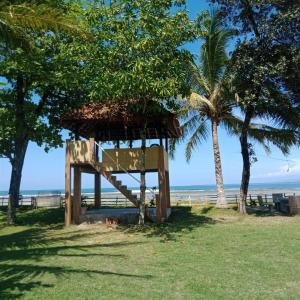 比哈尔Karang Besi Losmen的海滩上一座有棕榈树的救生塔