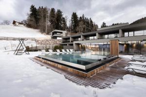 阿维兰奥Hotel Viertler的雪中带游泳池的房子