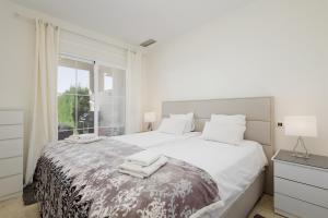 伊斯坦Apartment Balcones del Lago的白色卧室配有一张大床和毛巾
