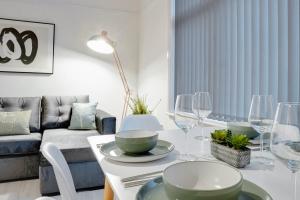 伯肯黑德Stylish 2 bedroom flat - 15 minutes to Liverpool City Centre的客厅配有带盘子和酒杯的桌子