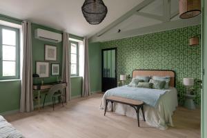 ChasselayDomaine de Bellescize的一间卧室设有绿色的墙壁、一张床和一张书桌