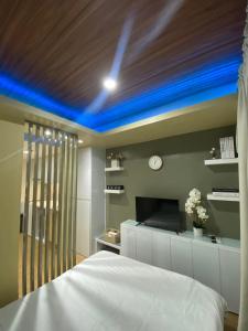 大雅台NA Suites at Pine Suites Tagaytay的一间卧室配有一张带蓝色天花板的床。