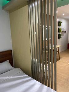 大雅台NA Suites at Pine Suites Tagaytay的一间卧室设有一张床和一个木制隔板