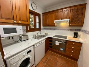 多列毛利诺斯M&H Torremolinos的厨房配有洗衣机和微波炉。