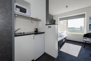 哥本哈根卡宾公寓式酒店的客房设有厨房和带窗户的床。