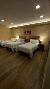 萨尔塔Adobe Suites的配有2张床的木地板客房