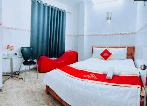 胡志明市Trung Bảo Hotel的一间卧室配有一张床和一张红色椅子