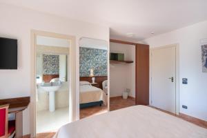 罗卡拉索Hotel Rasinus的一间卧室配有床、水槽和镜子