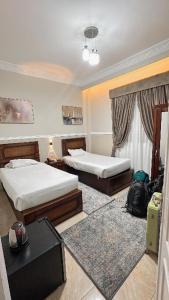Banī ‘AţīyahAl Saraya Hotel Bani Sweif的酒店客房设有两张床和一张桌子。