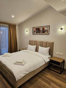 埃里温Hotel Avenue 30的一间卧室配有一张大床和两条毛巾