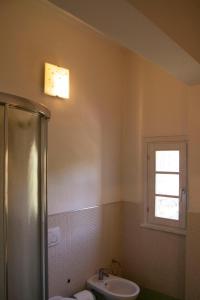 芬奇Appartamento a Vinci的一间带水槽和卫生间的浴室以及窗户。