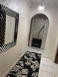 康斯坦丁Très belle appartement的走廊上设有黑白地毯和镜子