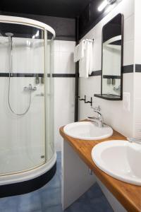 蒙特勒Marché 28 Guesthouse的一间带玻璃淋浴和水槽的浴室