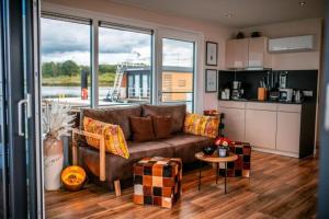 KlittenHausboot Skyline的一间带棕色沙发的客厅和一间厨房