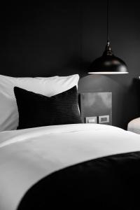 查汶BedTime Hotel Samui的黑白卧室配有床和灯