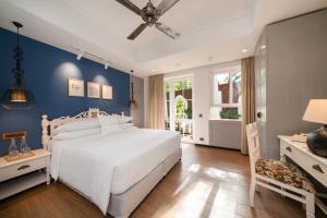 MoiraStorii By ITC Hotels Moira Riviera的卧室配有白色的床和蓝色的墙壁