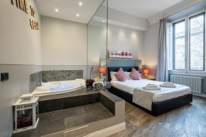 佛罗伦萨凯鲁比尼宫主题公寓的卧室设有大浴缸、床和浴缸。